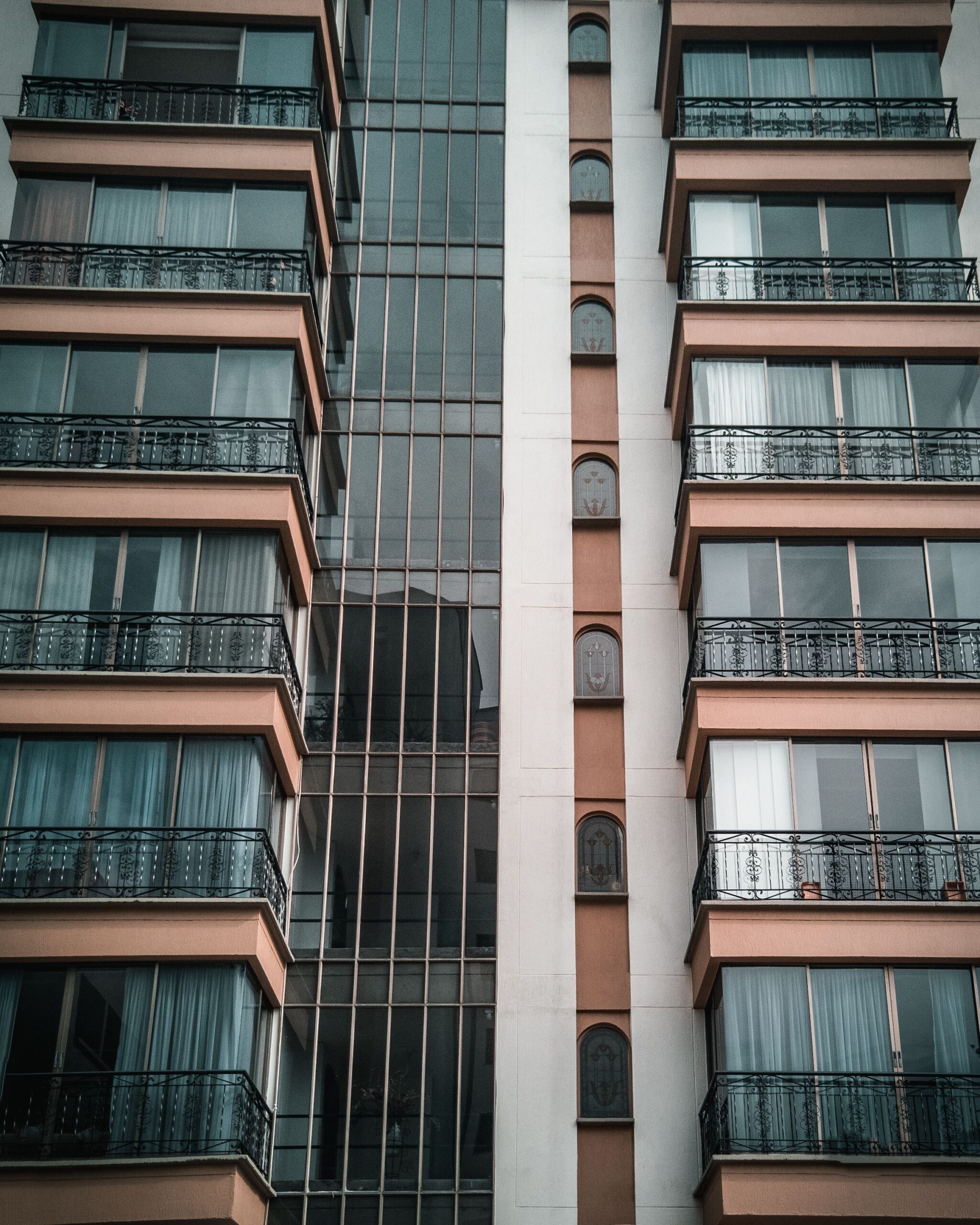 Low angle view of a modern apartment building with glass windows and balconies in Dubai