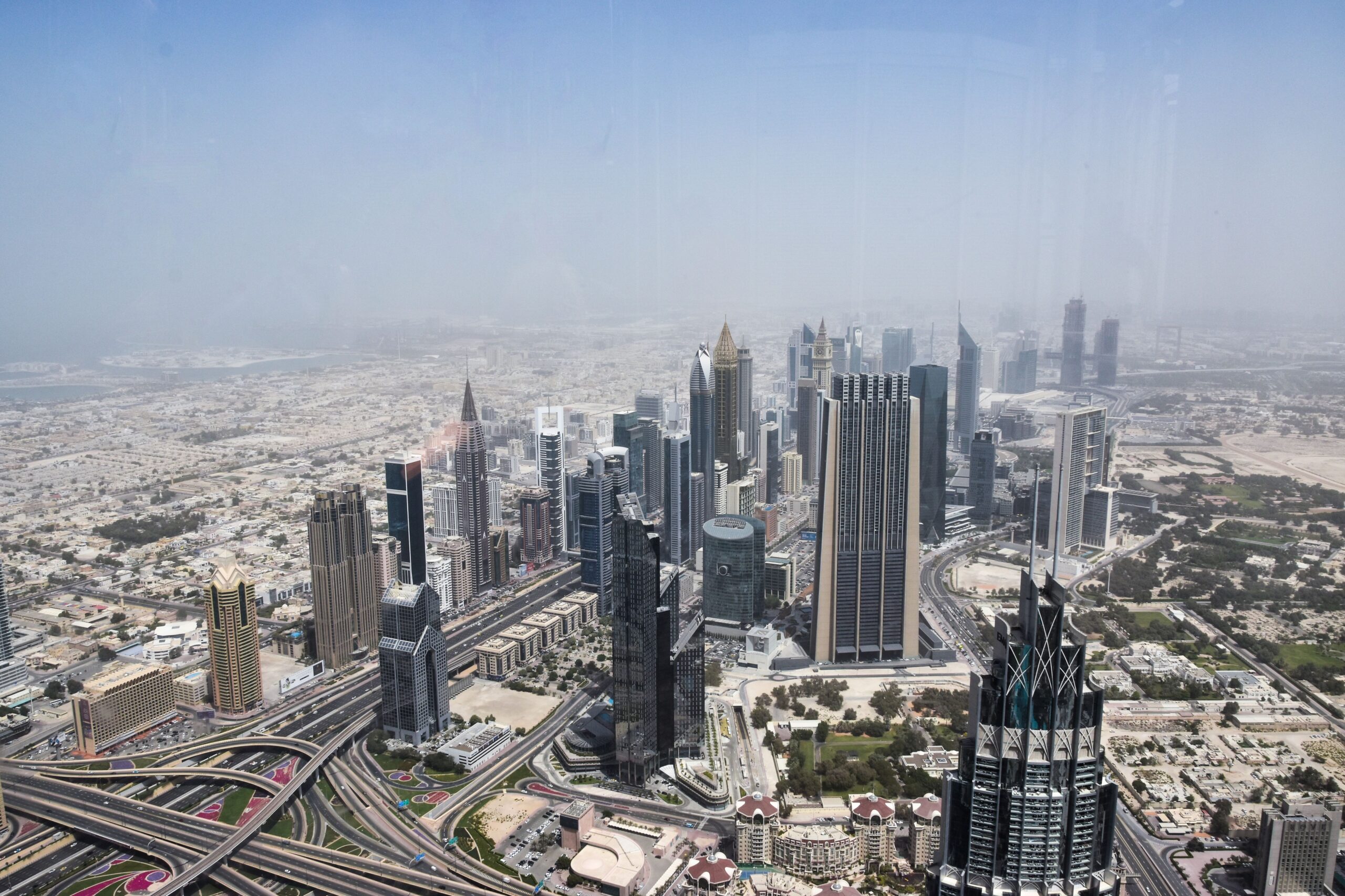 Aerial view of the Dubai skyline with residential and office towers and highways