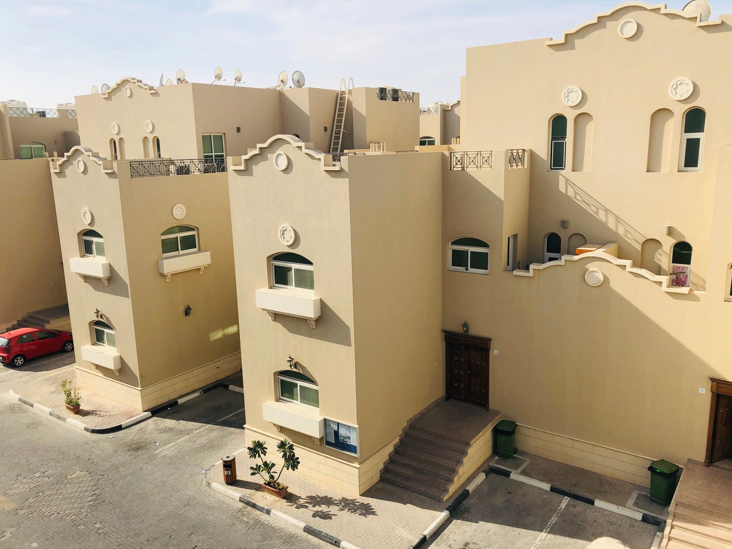 Sand-colored Gulf-style low-rise townhouse row near Westar Crest, JVC