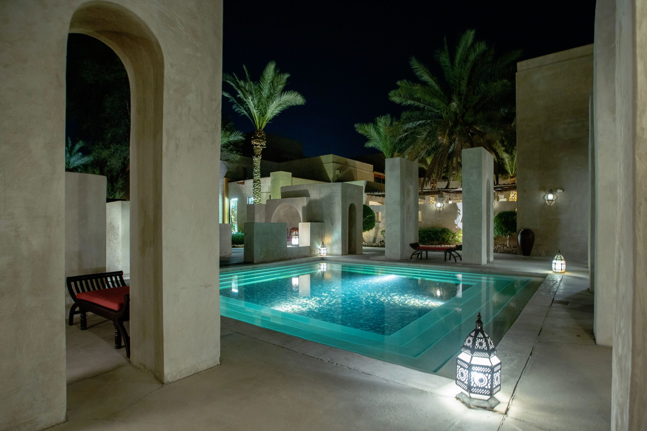 Villa pool terrace at night with Arabian architecture and palm trees in Dubai