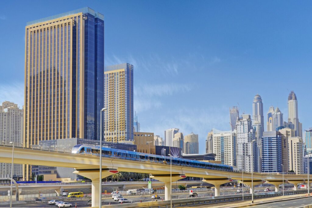Dubai skyline with a metro train on an elevated track and high-rise towers behind