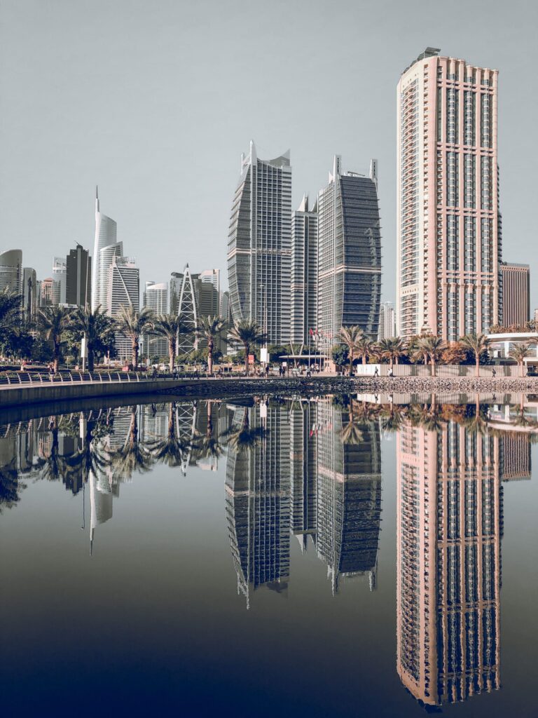 Dubai skyline with high-rise towers reflected in a calm waterfront lake, representative of Lake Terrace in Jumeirah Lake Towers Cluster D