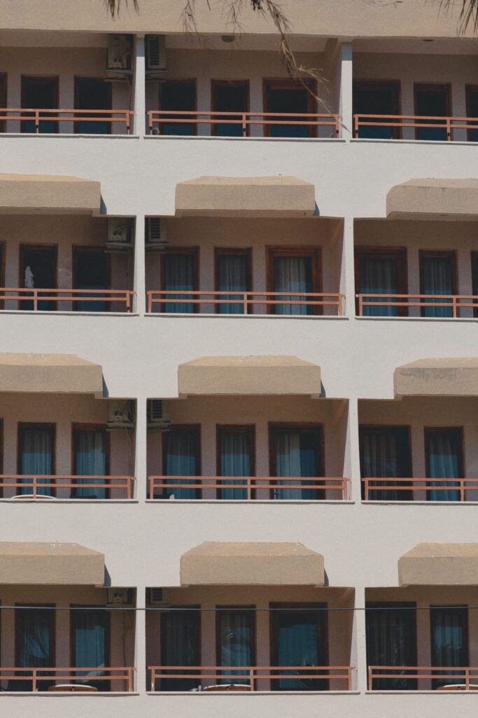 Cream low-rise Dubai apartment facade with repeating balconies and terracotta railings, representative of Prime Residency's Spain Cluster architecture in International City