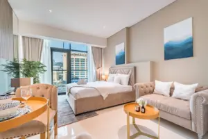 Studio at Seven Palm with a double bed, blush velvet sofa and a small round table by the window