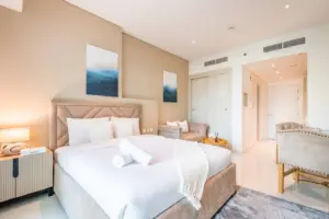 Bedroom at Seven Palm with a king bed, bolster cushion and framed blue abstract art